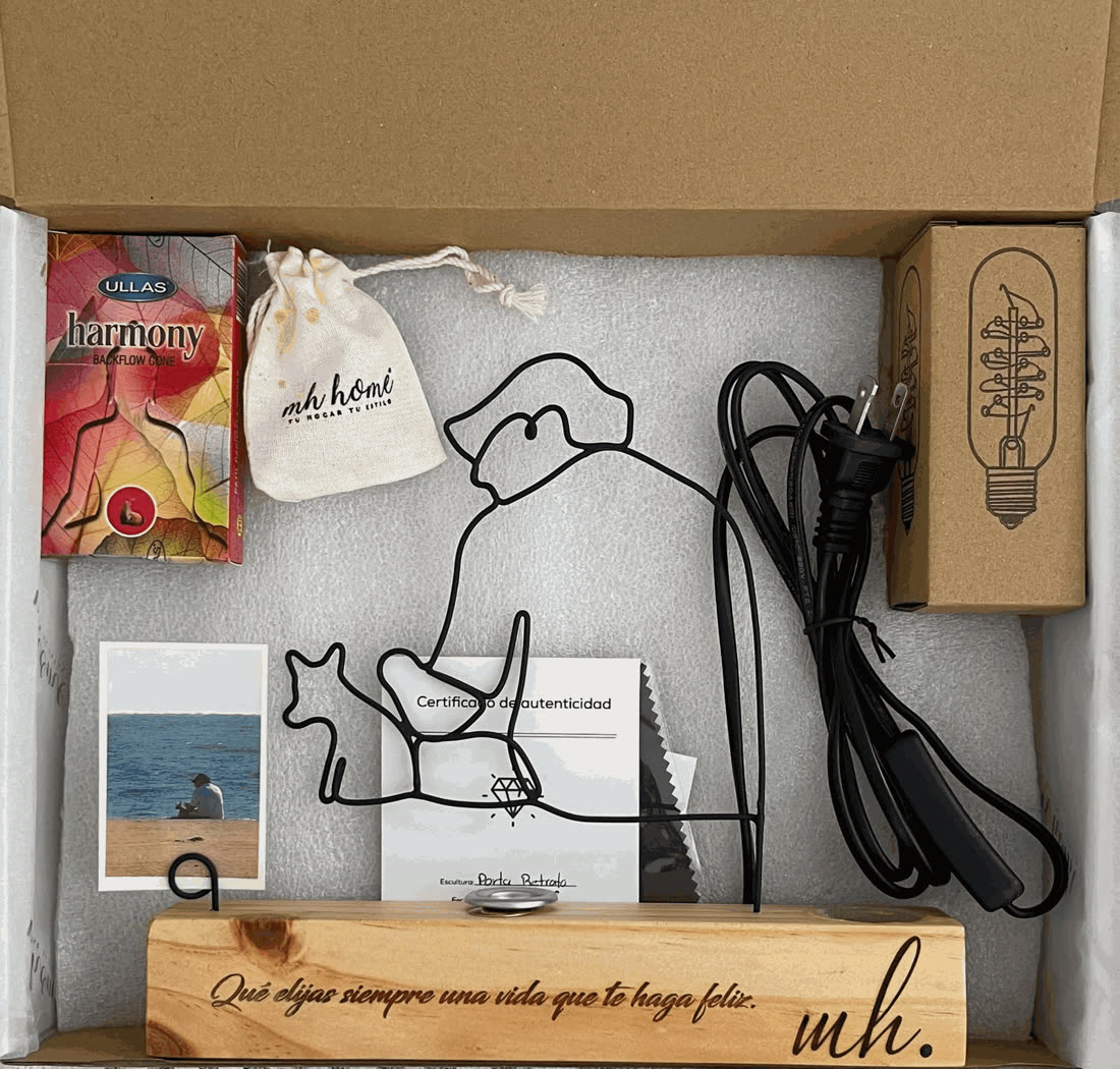 Caja abierta de MH Home con la escultura porta retrato de alambre sobre base grabada, foto impresa, certificado de autenticidad, foco vintage con cable, incienso de cono y costalito del Kit Zen.